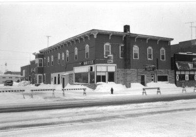 An old building with blockades to keep cars from going thru in the deep snow